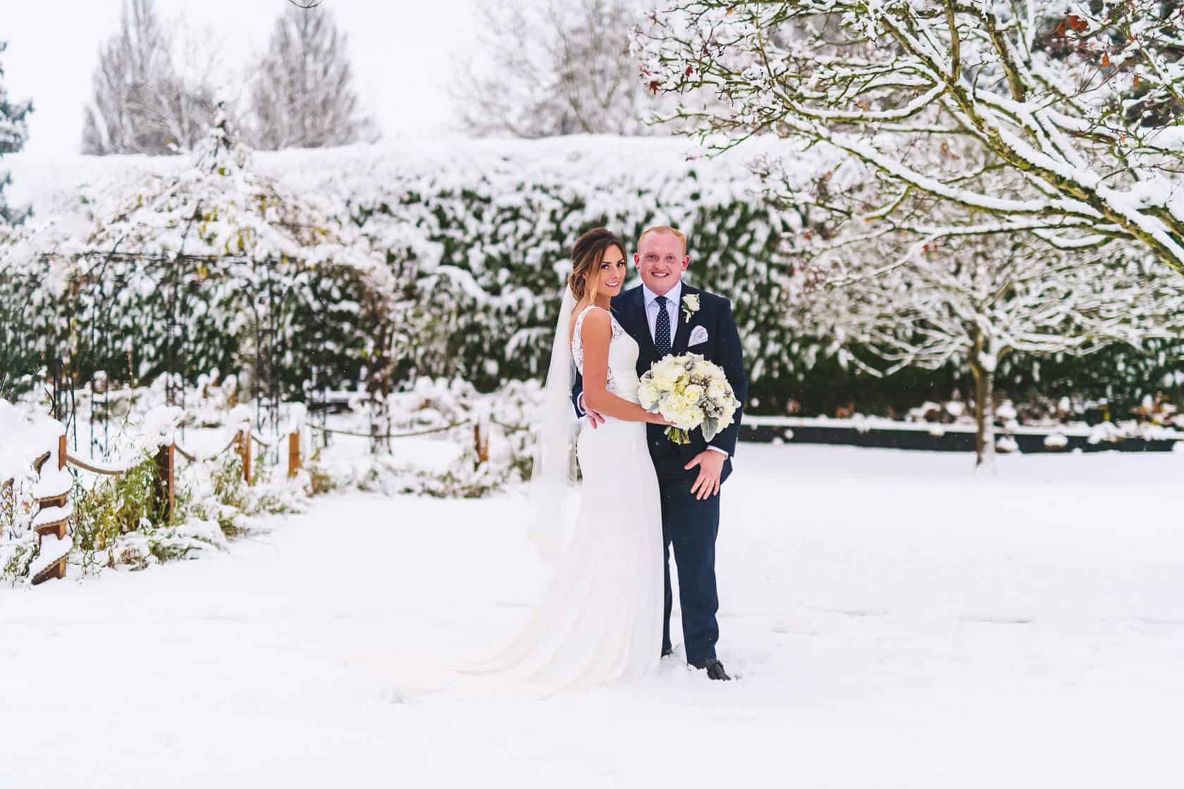 Demi and Louis standing in the Walled Garden at Gaynes Park, after it has been snowing